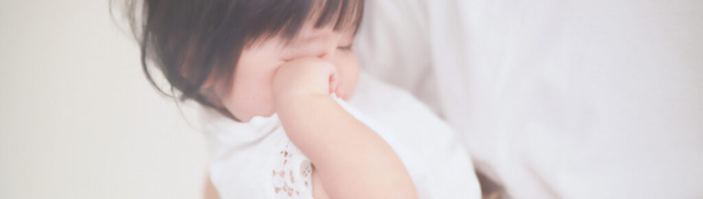ねむたくて目をこするこども